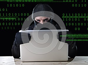 Hacker man in black using computer laptop for criminal activity hacking password and private information