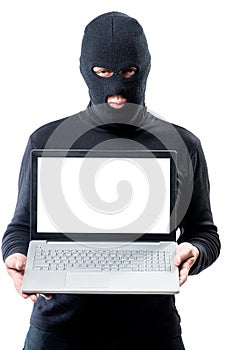 Hacker in a mask with a laptop, space for writing on the laptop`