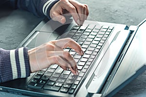 Hacker the programmer is typing on the keyboard of the laptop to hack the system.