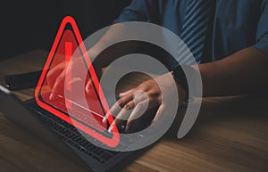 Hacker or programmer using laptop with triangle caution warning sign, coding, cryptography, hacker, crime, virus,