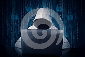 Hacker typing on a laptop with binary code in background