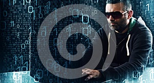 Hacker typing on laptop computer keyboard binary code background