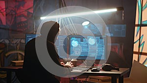 Hacker using computer to run malicious code in foggy dark basement