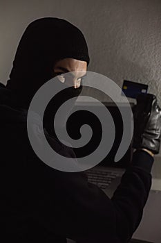 Hacker using debit card and laptop