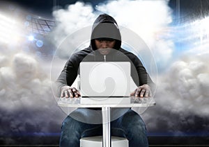 Hacker using a laptop in front of cloudy background