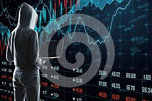 Hacker using laptop and looking on glowing stock chart