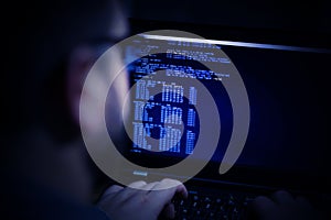 Hacker using laptop. Lots of digits on the computer screen
