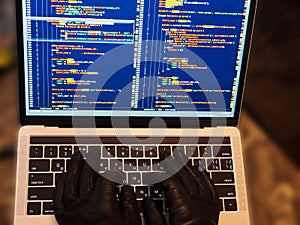 Hacker using malicious code or virus program for anonymous cyber attack. Cybercrime, hacking and technology concept
