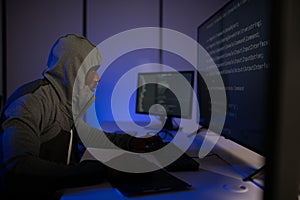 African american Hacker Using Multiple Computers For Stealing Data On Desk