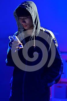 Hacker using smartphone for phishing attack and data theft in dark cyber environment