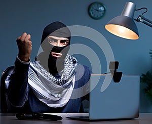 Hacker wearing balaclava mask hacking computer