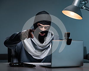 Hacker wearing balaclava mask hacking computer