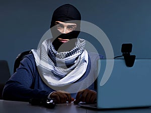 Hacker wearing balaclava mask hacking computer