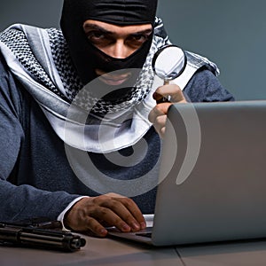 Hacker wearing balaclava mask hacking computer