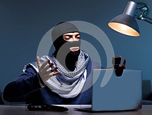 Hacker wearing balaclava mask hacking computer