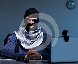 Hacker wearing balaclava mask hacking computer