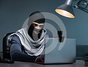 Hacker wearing balaclava mask hacking computer