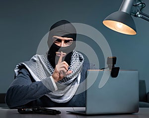 Hacker wearing balaclava mask hacking computer
