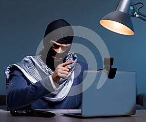 Hacker wearing balaclava mask hacking computer