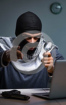 Hacker wearing balaclava mask hacking computer