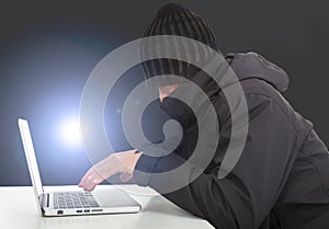 Hacker working with a laptop computer in the darkness