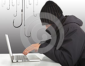 Hacker working with a laptop computer and hooks