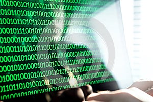 Hacker writing code with laptop computer.
