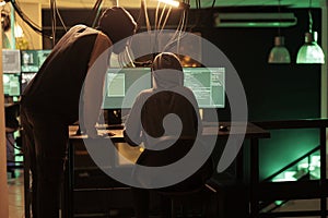 Hackers coding malicious software, cracking database password