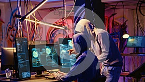 Hackers in neon lit hideaway