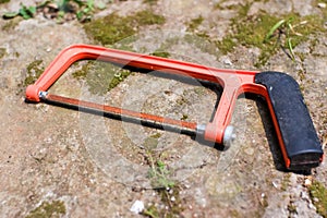 The hacksaw hand tool is placed on the ground