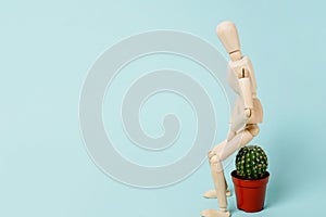 Haemorrhoids. wooden man sitting on a cactus.Vascular structures in the lower part of the rectum and acute pain concept, blue