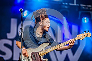 Sexy young guitarist with braids performing on stage