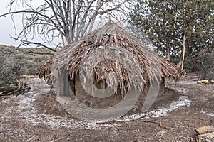 Hail falls on thatched adobe hut