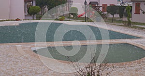 Hail in a summer storm. Ice balls heavily hit the swimming pool