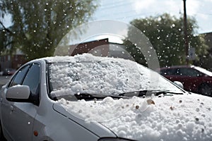hailstones piled high on a car hood after a storm