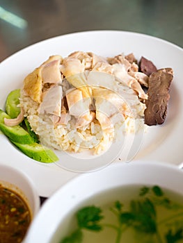 Hainanese chicken rice on a plate with soup