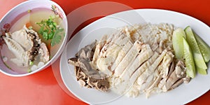 Hainanese chicken rice special set close up photo on red desk served with hot soup, Asian food in Thailand