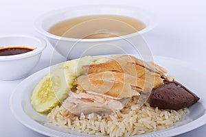 Hainanese chicken rice, steamed chicken, chicken blood and white rice on brown cloth background.