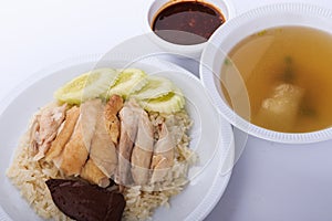 Hainanese chicken rice, steamed chicken, chicken blood and white rice on brown cloth background.