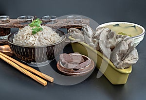 Hainanese chicken rice (Steamed chicken with rice) is sprinkled with Coriander and Pork blood puddings.