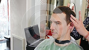 Hair analyzer. Trichologist working with client in modern clinic. Examining hair using dermatoscope. Consultation of a