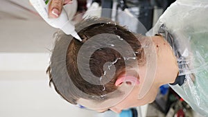 Hair analyzer. Trichologist working with client in modern clinic. Vertical footage. Examining hair using dermatoscope