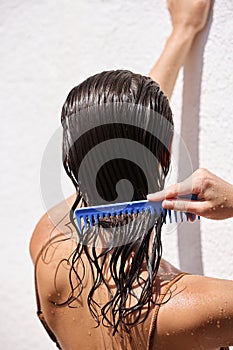 Hair Beauty. Closeup Of Woman Hairbrushing With Comb And Using Conditioner