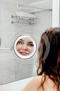 Hair and body care. Girl uses protection moisturizing cream and oil. Beautiful young woman touching her wet hair