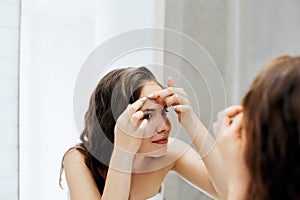 Hair and body care. Girl uses protection moisturizing cream and oil. Beautiful young woman touching her wet hair