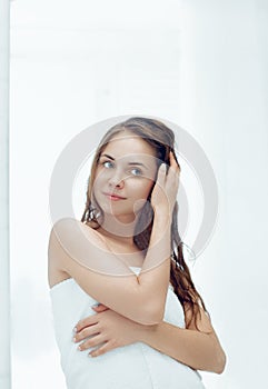 Hair and body care. Woman touching wet hair and smiling while looking in the mirror.