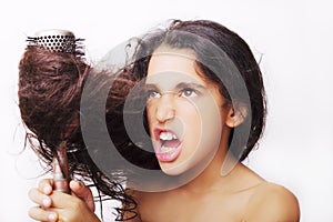 Hair care concept with portrait of girl brushing her unruly hair