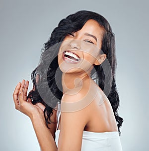 Hair care, laughing and portrait of a woman with beauty isolated on a grey background in studio. Happy, smile and a