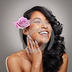 Hair care, smile and woman with rose in studio with beauty, health and salon treatment for confidence. Happy, wellness