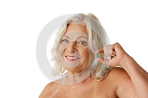 Hair care, treatment. Smiling senior woman holding hair vitamin capsule, taking care after hair look against white